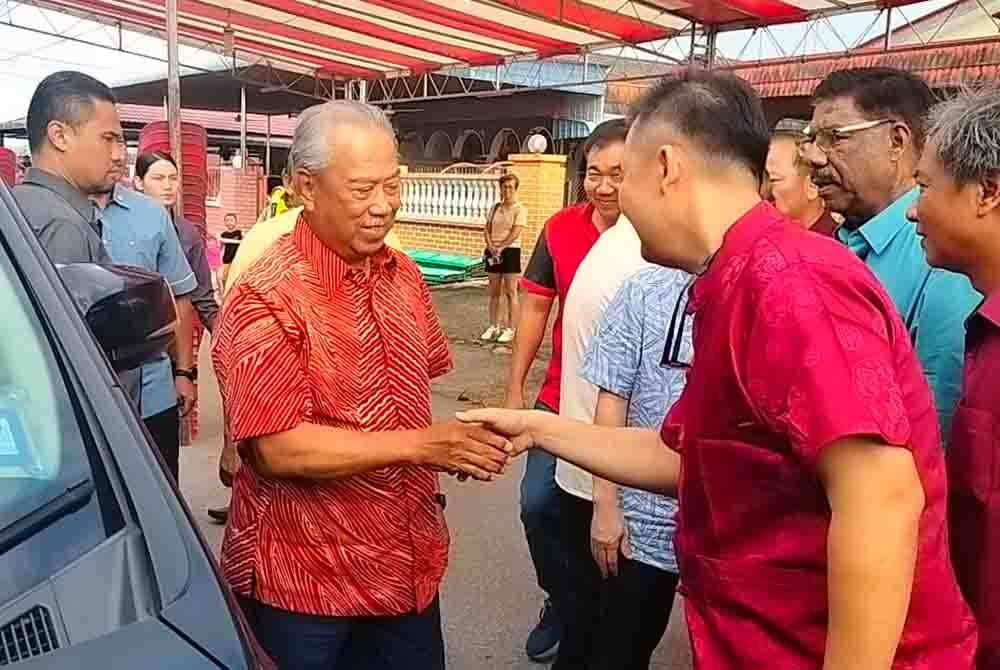 Muhyiddin (kiri) tiba pada acara Sambutan Tahun Baharu Cina Parlimen Pagoh di Bukit Pasir pada Jumaat.