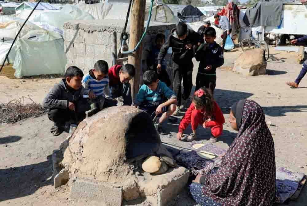 Wanita Palestin ini membakar roti di Khan Yunis. Penduduk Gaza kini mengalami kebuluran. - Agensi