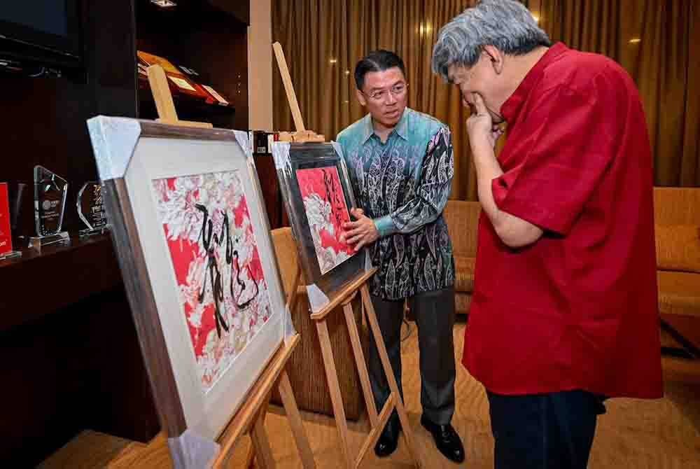Kor Ming mempersembahkan sepasang karya seni Tahun Naga kepada Sultan Sharafuddin.