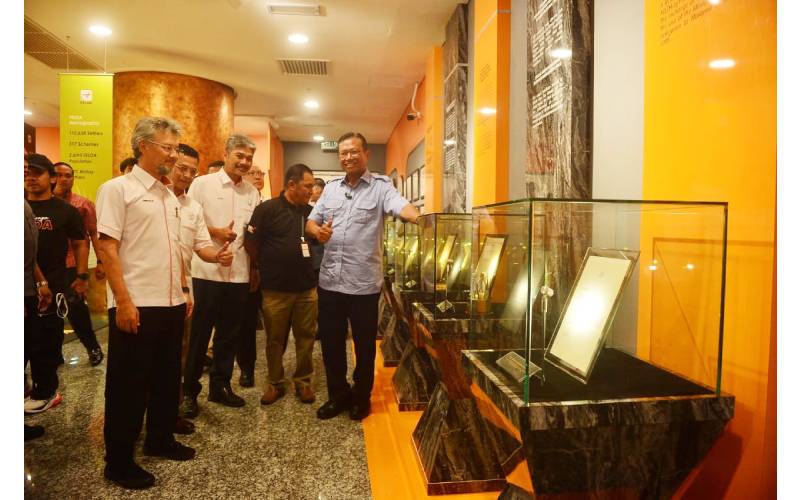 Ahmad Shabery (kanan) menunjukkan isyarat bagus sambil memperlihatkan koleksi plak anugerah serta pencapaian FELDA yang dipamerkan di Menara FELDA.