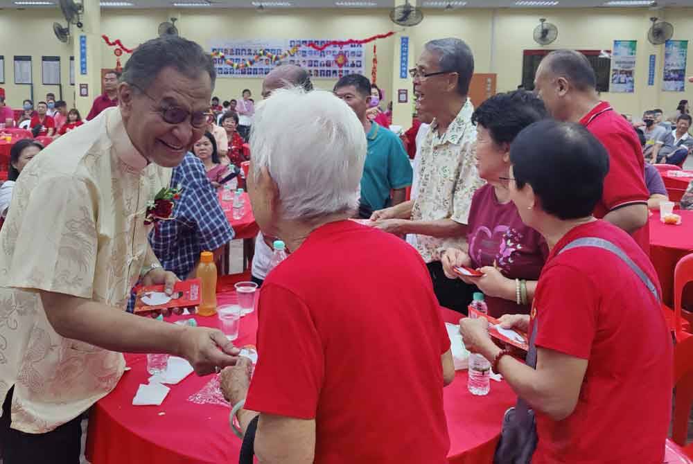 Dzulkefly (kiri) memberikan sumbangan kepada warga emas pada Majlis Sambutan Tahun Baharu Cina Parlimen Kuala Selangor di SJKC Yuk Chih, Bestari Jaya pada Sabtu malam.