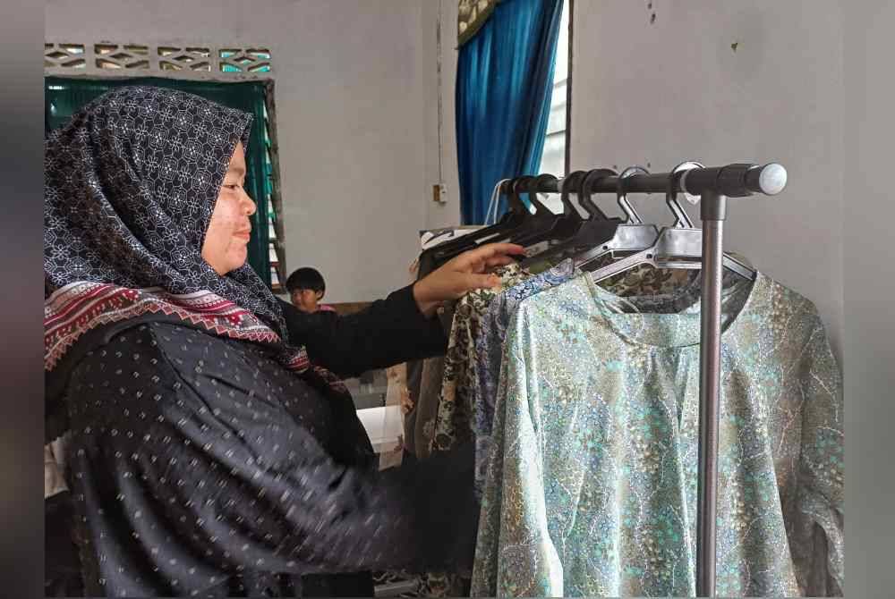 Nor Ain Shuhada menyusun baju yang telah siap dijahit buat pelanggannya.