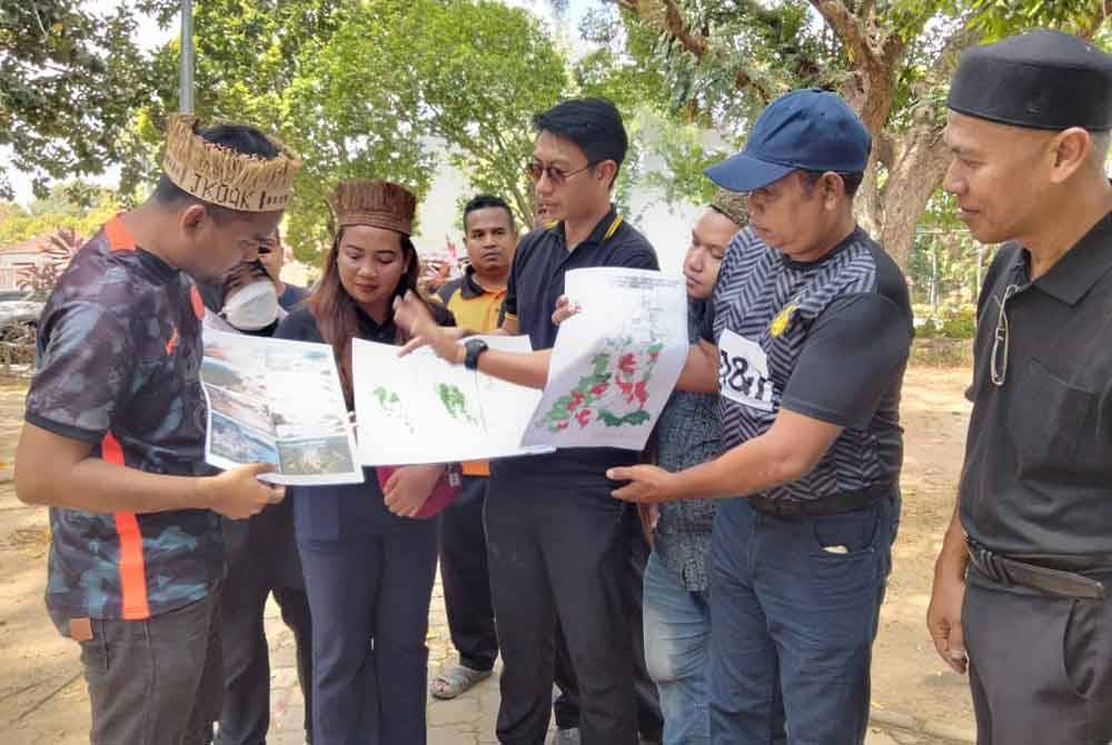 Hafizudin bersama wakil NGO menunjukkan peta kawasan di negeri ini yang didakwa akan mengalami kerosakan jika pembangunan KSAS diteruskan.