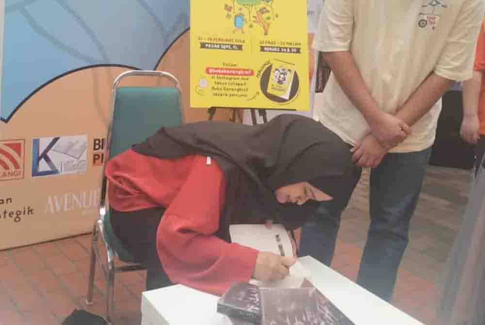 Nurul Syahida melayani peminat selepas majlis pelancaran novel Doppelganger di Pasar Seni, Kuala Lumpur pada Ahad.