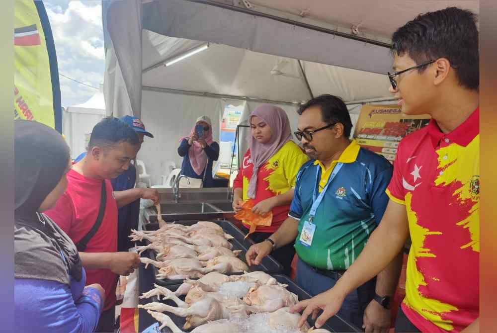 Zurihanmi (dua dari kanan) melayani pengunjung di gerai jualan ayam di PMR Zon Tengah.