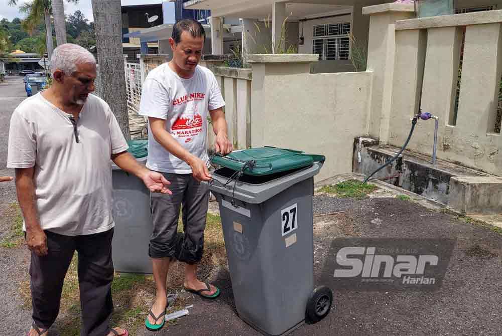 Penduduk terpaksa ikat penutup tong sampah bagi mengelak diselongkar monyet.