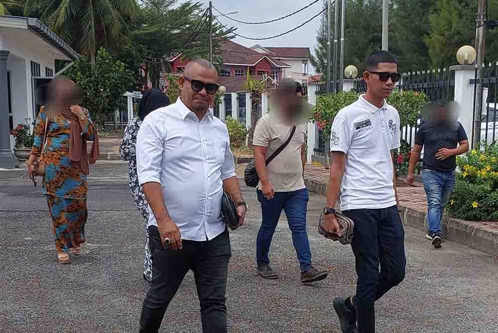 Husin (kiri) bersama anak lelakinya, Muhammad Aieril Amirul (kanan) didakwa di Mahkamah Majistret Dungun pada Selasa.