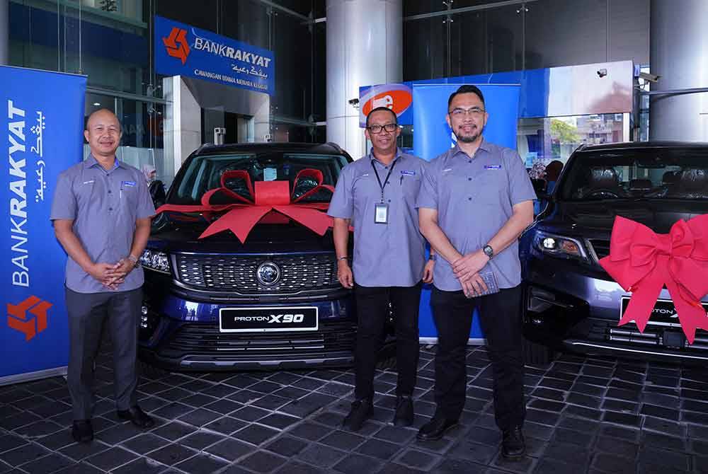 Nizam (tengah) bergambar bersama hadiah utama Kempen Ramadan Raya Tulus Ikhlas Bank Rakyat di Menara Kembar Bank Rakyat pada Rabu. Foto Sinar Harian-MOHD HALIM ABDUL WAHID