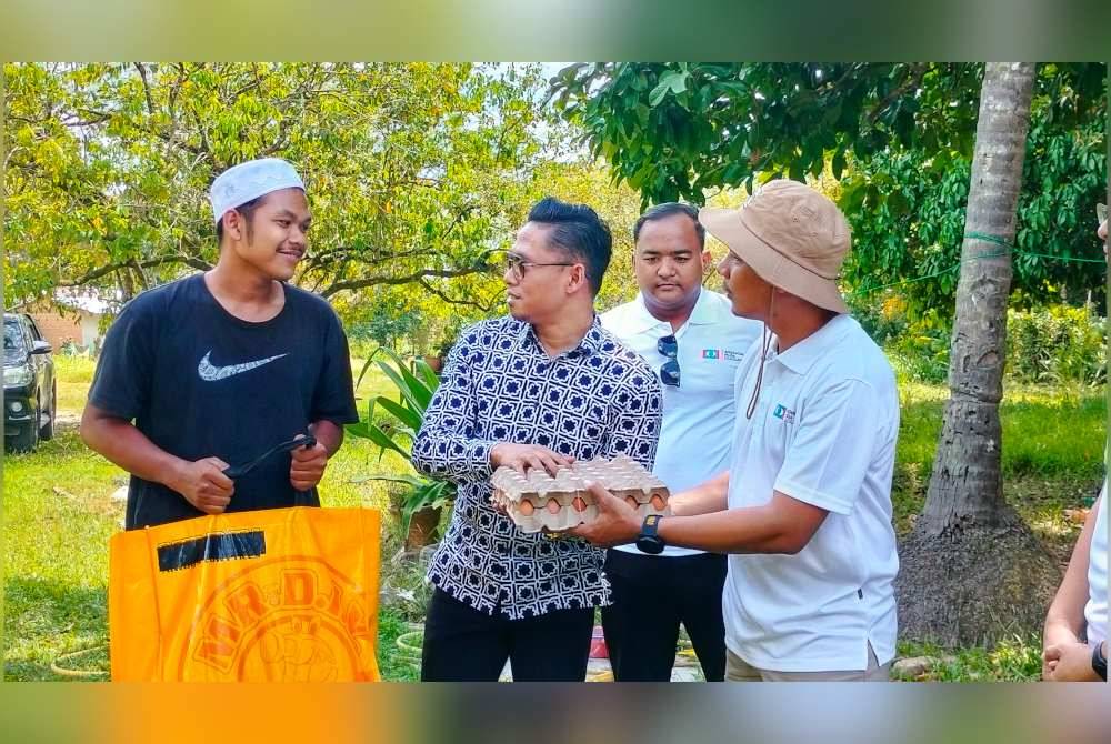 Mohd Aidil (kiri) ketika menerima sumbangan dan kunjungan Ahmad Umar (tengah) bersama Syahril (Kanan)