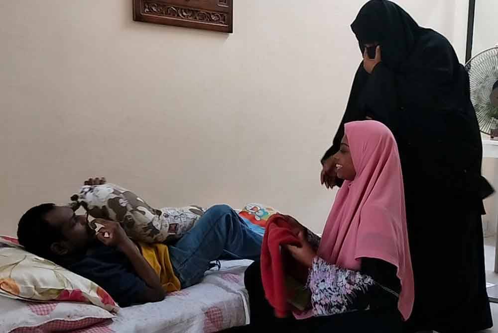 Ain (kanan) mambantu ibunya menguruskan Nihal yang terlantar.