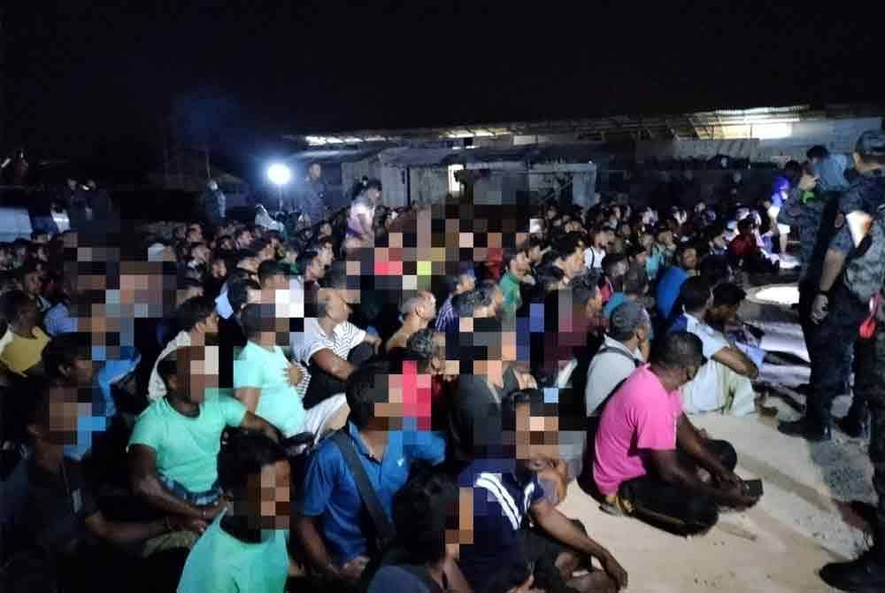 Sebahagian warga asing yang diperiksa dalam Ops Sapu di sebuah tapak pembinaan di Tiang Dua pada awal pagi Khamis.