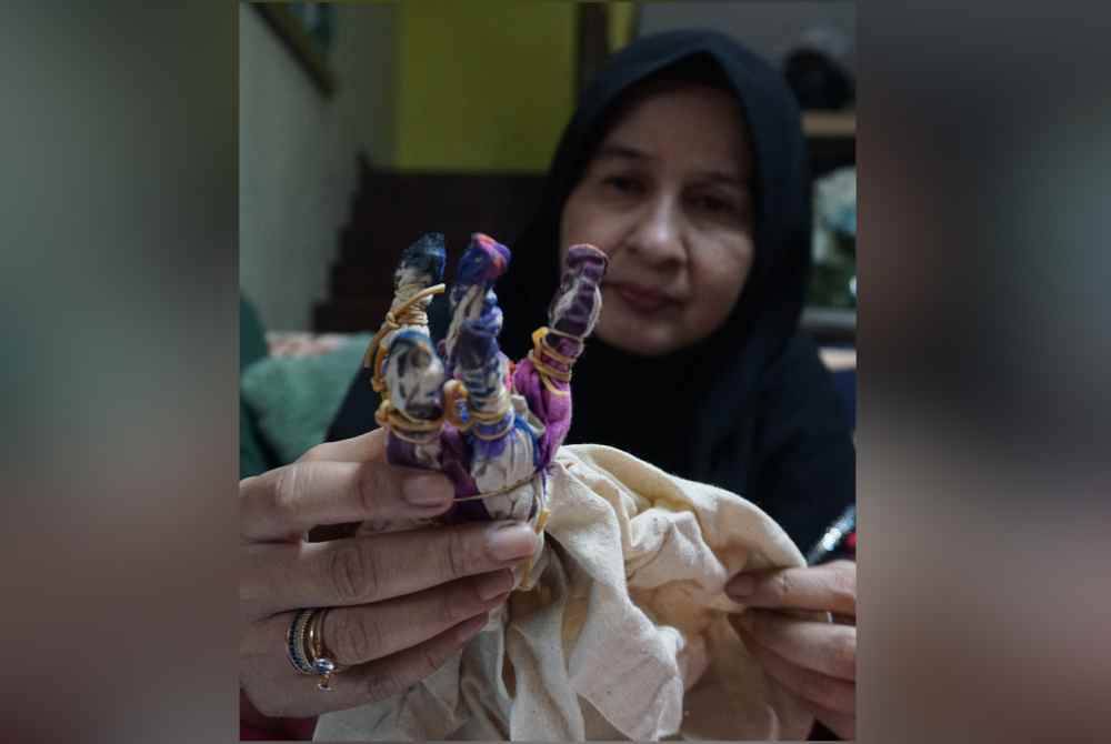 Noor Atikah Abdul Ghani menunjukkan kain pasang yang dihasilkan menggunakan kaedah 'tie dye' (ikat dan celup). Foto Bernama