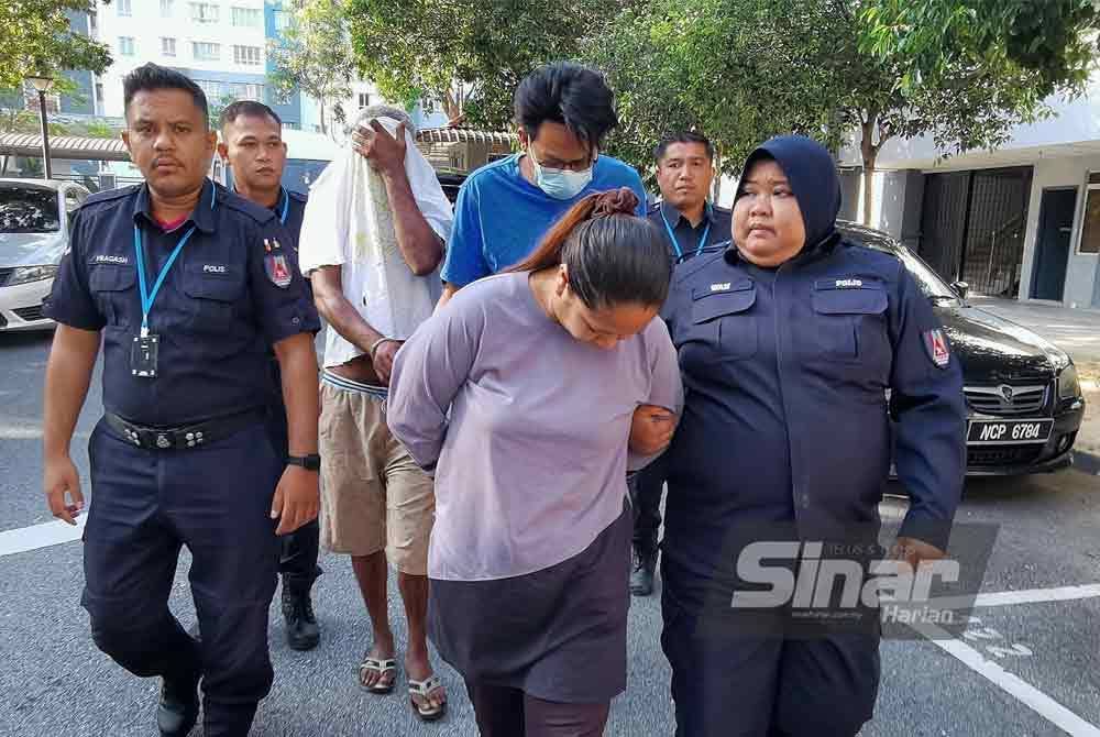 Amirul Mu'mini (baju biru) dan Nor Asedah (depan) diiring polis ketika hadir ke Mahkamah Majistret Seremban bagi menghadapi empat pertuduhan mencuri.
