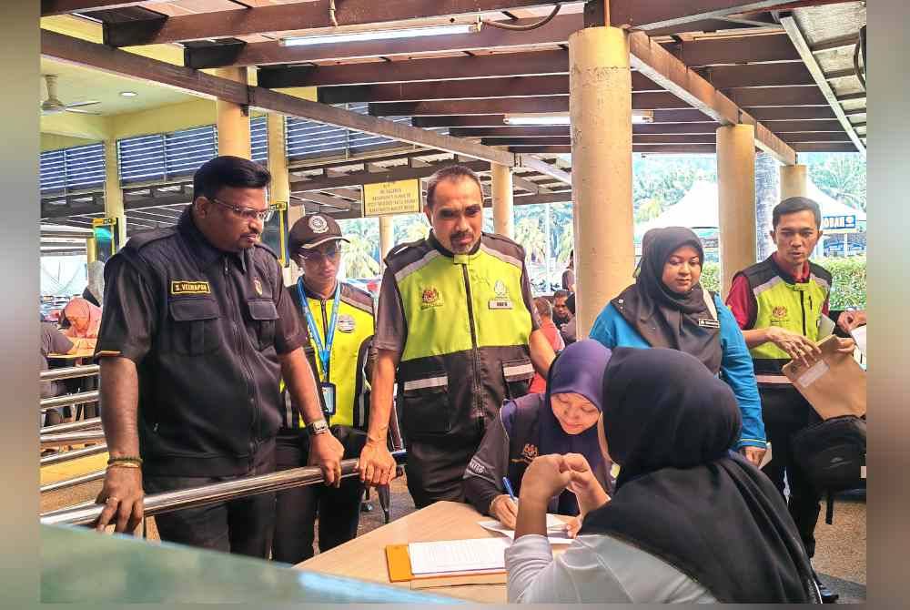 Nur Muhammad Bakhtir (tiga dari kiri) dan Veerapan (kiri) melihat pemeriksaan dokumen pekerja ketika Ops R&R diadakan pada Khamis.