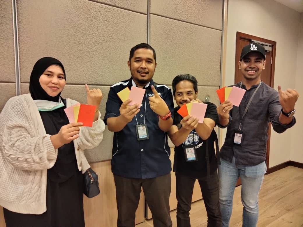 Yatimin (dua dari kiri) bersama pengamal media lain menunjukkan kertas undi dan jari yang dicelup dakwat sebelum proses mengundi
