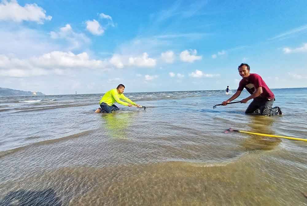 Yusri (kanan) dan Zubir gigih ke pantai seawal jam 3 petang untuk mencari kepah di Pantai Tanjung Lumpur.