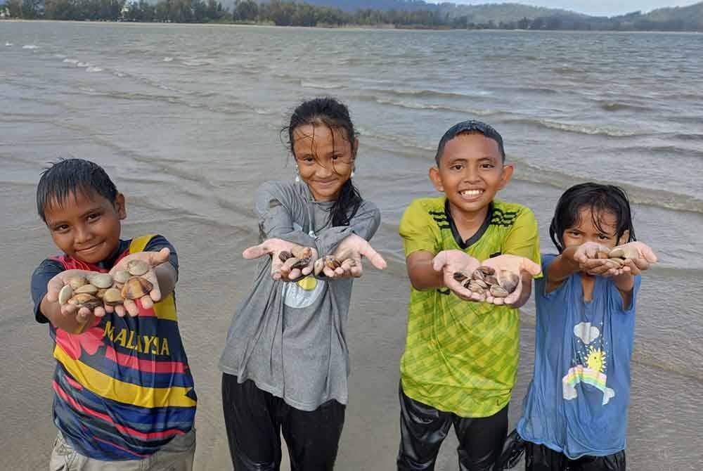 (Dari kiri) Aqil Asyraf Ismaun, 12, Puteri Eldalina Hadirah Azhar, 12, Rayyan Hakimi Mohd Razif, 12 dan Azwani Azhar, 9, menunjukkan kepah yang berjaya diperolehi di pesisir pantai Tanjung Lumpur.