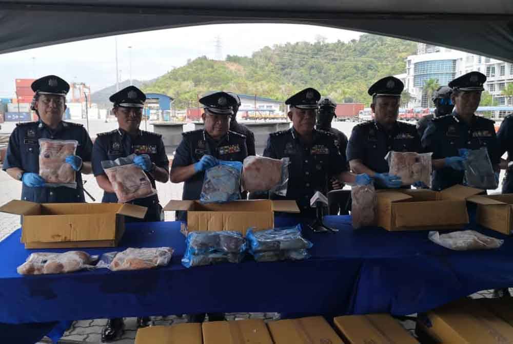 Mohd Nasir (tiga dari kanan) menunjukkan ayam beku yang dirampas JKDM Sabah melalui kontena di Pelabuhan Sepanggar, Kota Kinabalu.