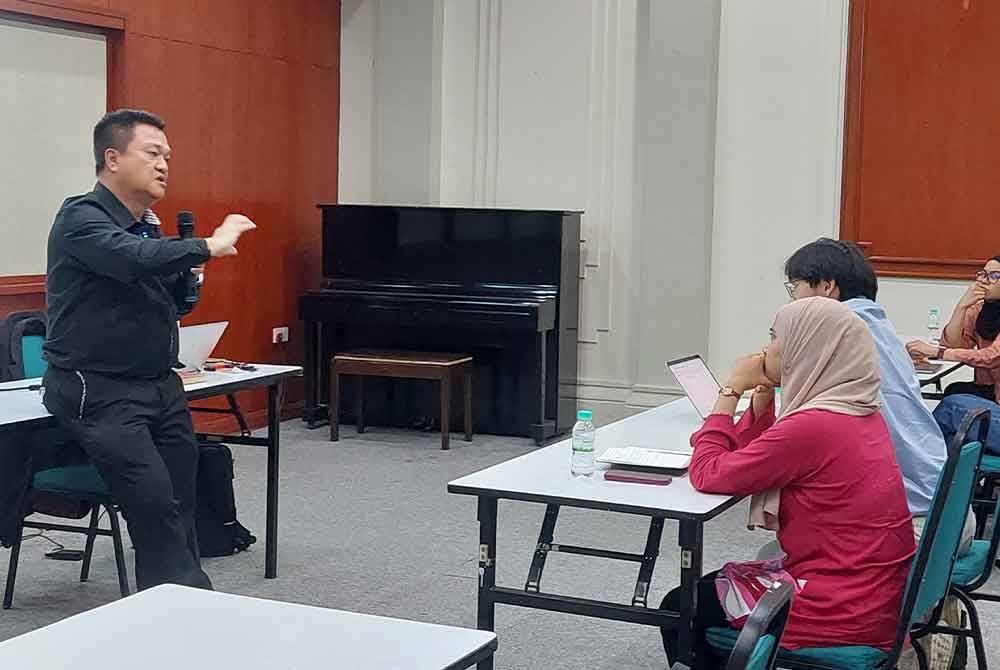 Chin Huat (kiri) mengendalikan kursus pintas APBT kepada pengamal media di ibu negara pada Jumaat.