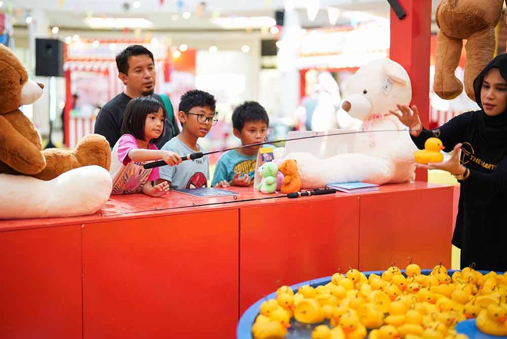 Pengunjung cilik bermain permainan karnival yang menyeronokkan di Karnival VIKids.