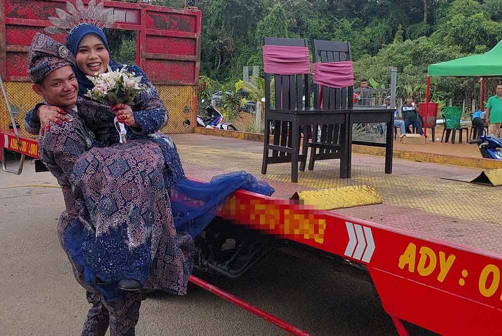 Muhammad Badrul Haikal membawa turun isterinya, Nurul Nazifah dari trak tunda