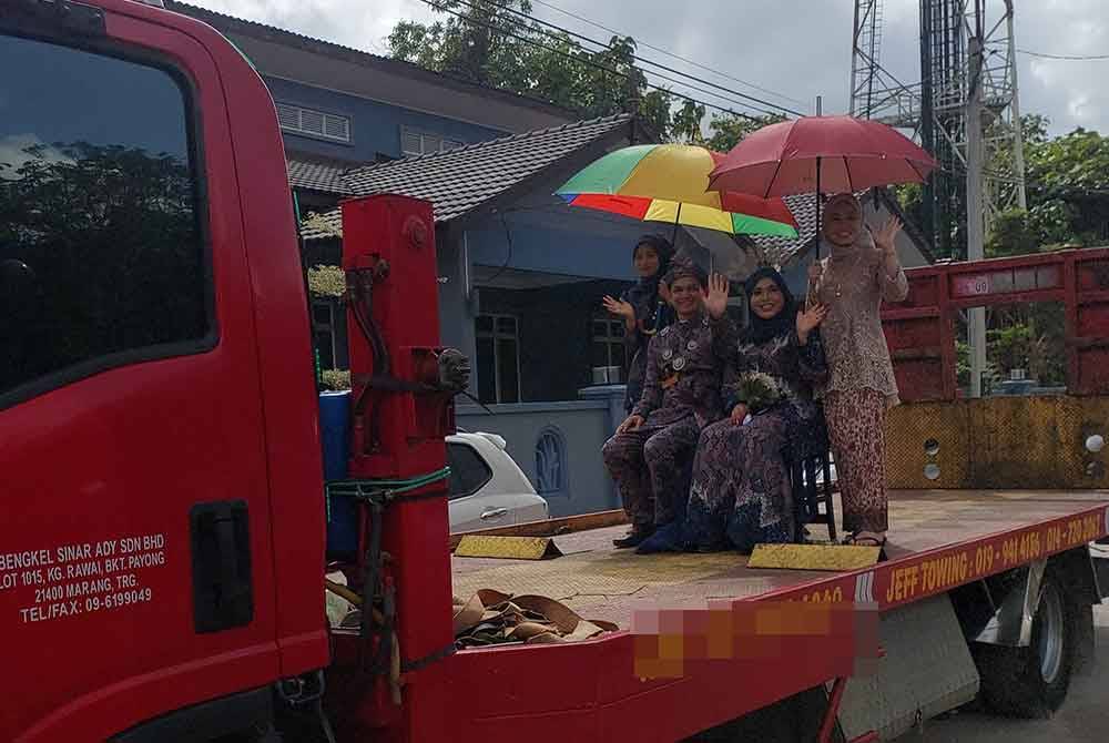 Pasangan pengantin diraikan dengan sambutan yang unik apabila diarak menaiki trak tun