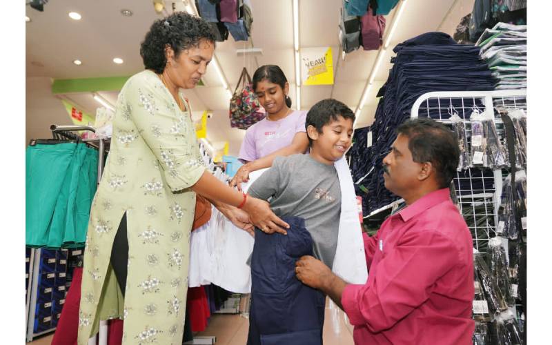 Vijaya (kiri) tidak melepas peluang mencari kelengkapan persekolahan dua anaknya dengan harga berpatutan di Pusat Pakaian Hari-Hari.
