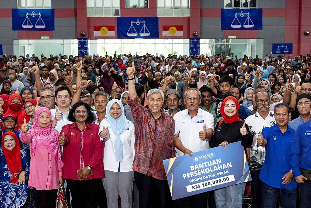 Ahmad Zahid bergambar bersama masyarakat setempat ketika hadir ke Majlis Penyampaian Sumbangan Kembali Ke Sekolah Parlimen Kawasan Bagan Datuk Tahun 2024 Kompleks UMNO Bagan Datuk hari ini. Foto Bernama