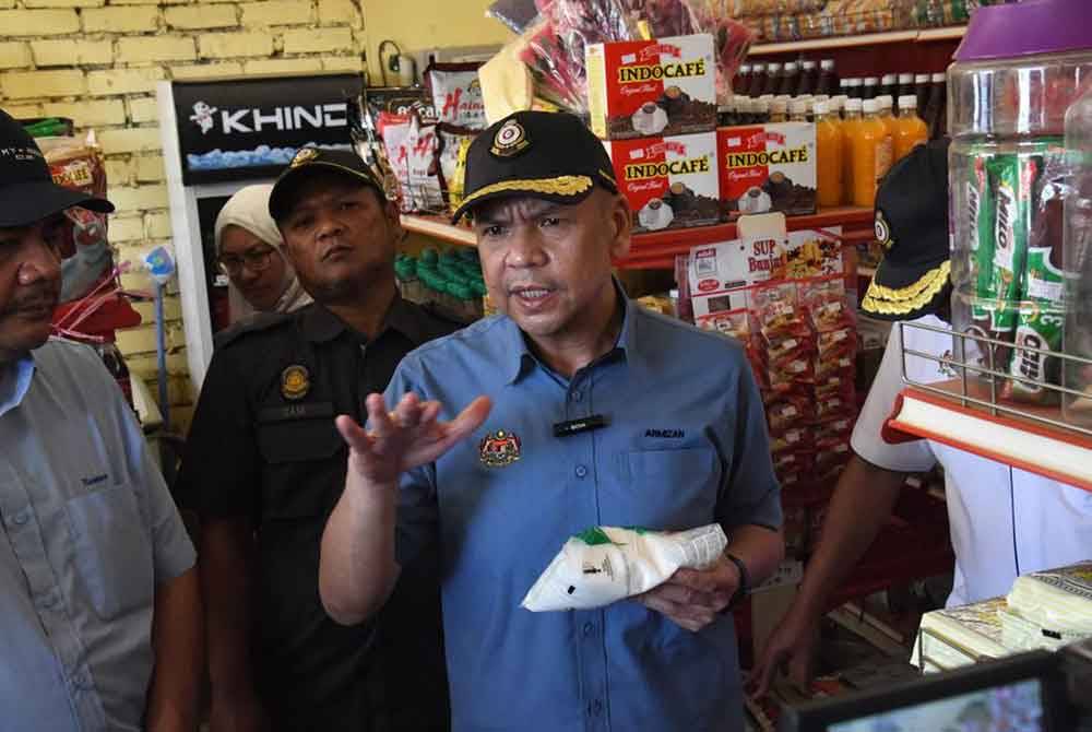 Armizan ketika melakukan pemeriksaan di salah sebuah kedai dalam lawatan kerja rasmi ke Pulau Sebatik, Tawau pada Ahad. - Foto: KPDN