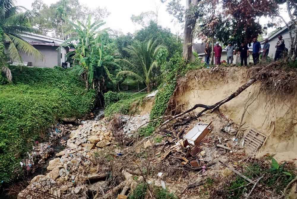 Keadaan tanah runtuh berdekatan rumah penduduk kesan daripada projek pengambilan pasir di Kampung Masjid Lama dekat Jeniang - Foto: Bernama