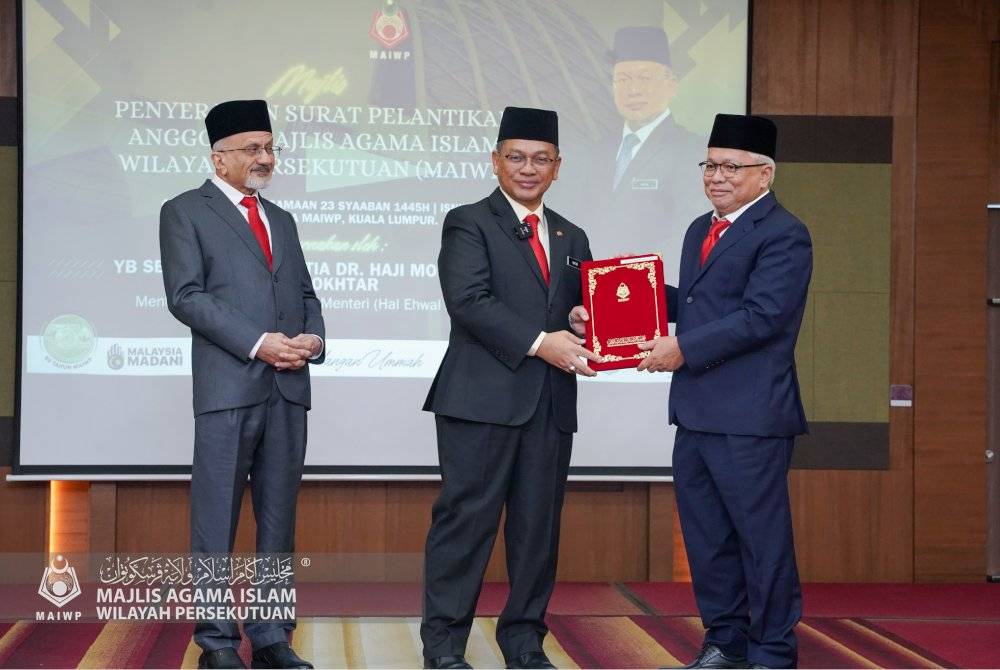 MOHD NA'IM (tengah) diiringi Pengerusi MAIWP, Syed Kamarulzaman (kiri) menyampaikan Surat Pelantikan kepada Ahli MAIWP, Datuk Hussamuddin. Foto MAIWP 