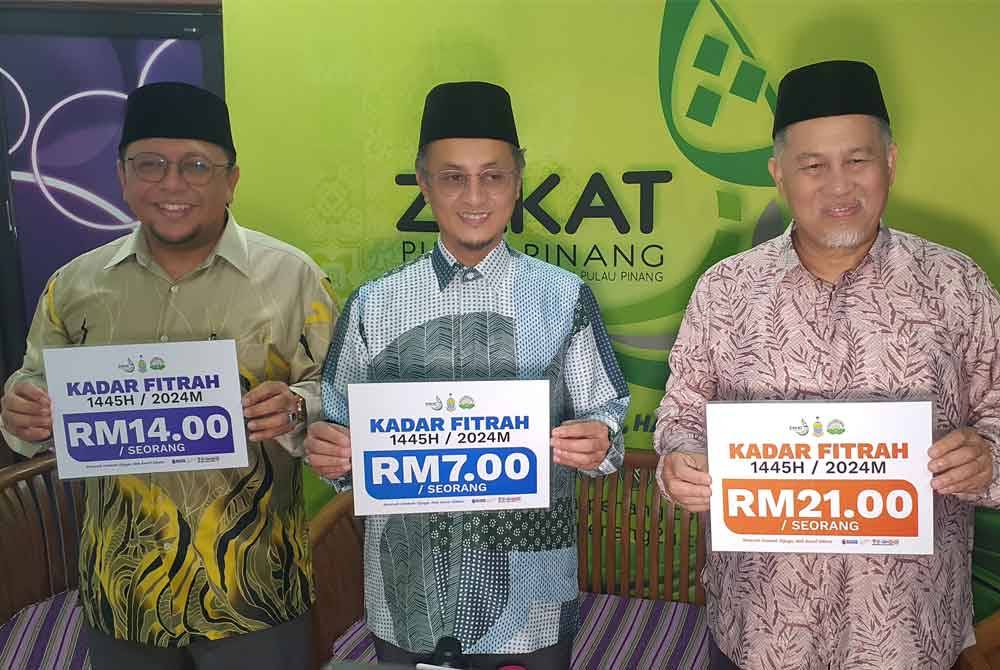 Mohamad (tengah) bersama Roslan (kanan) dan Amran (kiri) menunjukkan tiga kadar zakat fitrah yang ditetapkan tahun ini bagi Pulau Pinang.