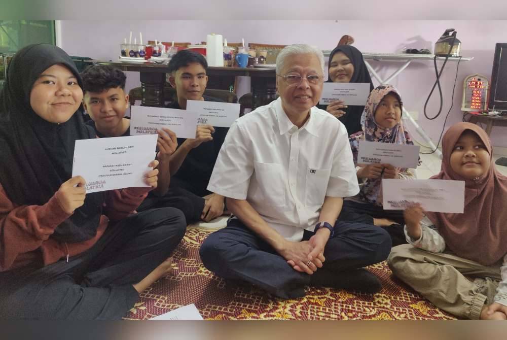 Ismail Sabri bergambar bersama enam daripada lapan beradik yatim piatu yang kehilangan ibu bapa akibat pandemik Covid-19 di Hulu Selangor pada Rabu.