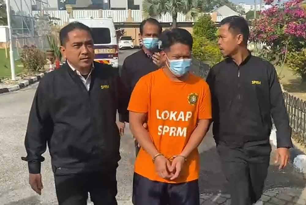 Tertuduh (tengah) ketika dihadapkan ke Mahkamah Sesyen di Kuala Terengganu pada Rabu.