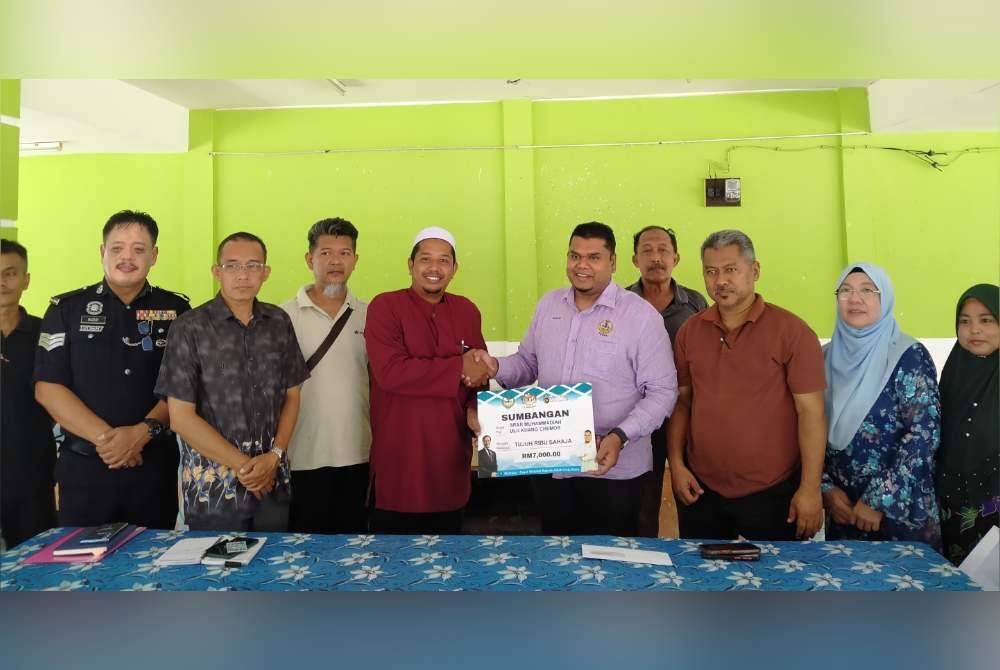 Muhamad Arafat menyampaikan sumbangan RM7,000 kepada pihak sekolah bagi membantu menyegerakan kerja-kerja pendawaian elektrik sebelum sesi persekolahan bermula.