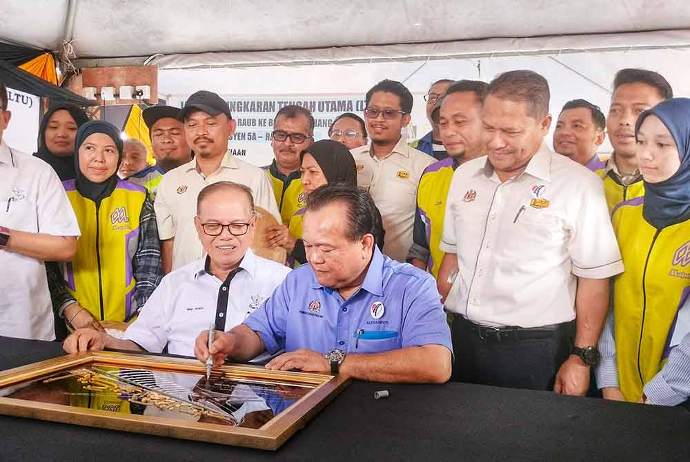 Alexander (kanan) menandatangani plak perasmian Seksyen 5A LTU Raub Bypass sambil diperhatikan Wan Rosdy (kiri) pada Khamis.