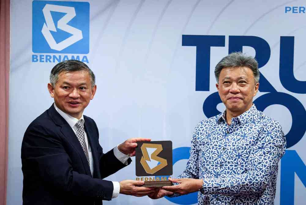 Chun Wai (kanan) menyampaikan cenderamata kepada Zheng Xuefang sempena kunjungan delegasi kedutaan China di Malaysia ke Wisma Bernama. Foto Bernama