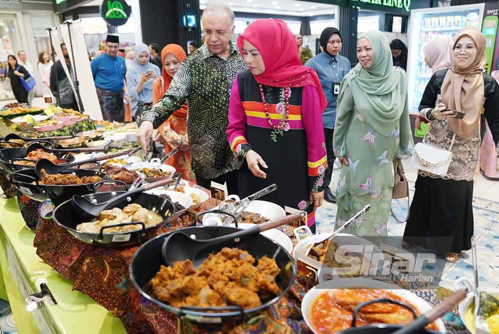 Noraini bersama Ameer Ali melihat menu Bazar Ramadan pada majlis Pelancaran Kempen Happening Raya yang diadakan di Pasaraya Mydin Seremban 2 pada Khamis. Foto SINARHARIAN/ROSLI TALIB