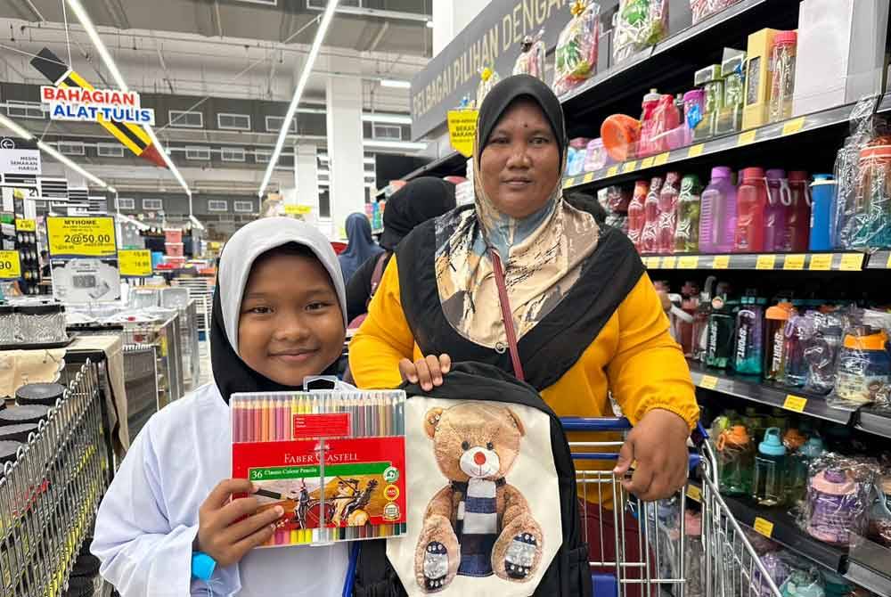Nor Syazlin Natasya (kiri) yang begitu terjua membeli kelengkapan sekolah bersama Mazuriani (kanan).