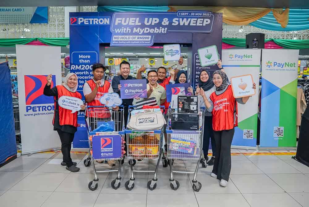 Sebahagian daripada peserta peraduan kempen ' ‘Fuel Up and Sweep with MyDebit’di pasar raya terkemuka di sini pada Jumaat. Foto Petron Malaysia.