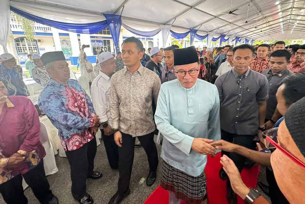 Anwar bersalaman dengan tetamu yang hadir ke Majlis Ramah Mesra di Ibu Pejabat Polis Daerah (IPD) SPT.