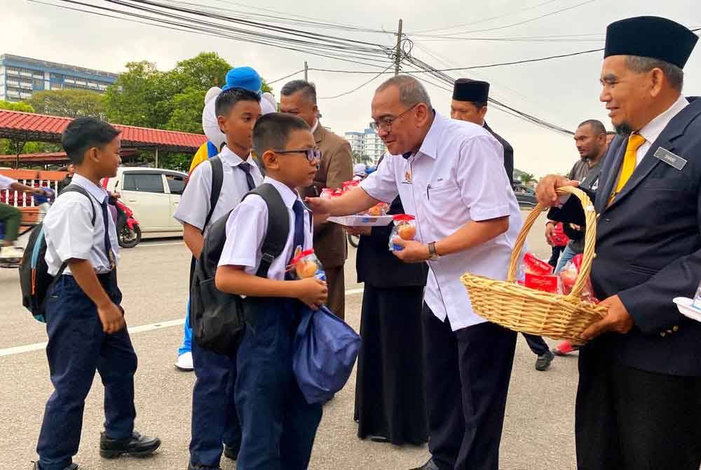 Mohd Zamri (dua dari kanan) menyambut kehadiran murid di SK Ismail Petra 1, Kota Bharu sempena hari pertama pembukaan sekolah sesi akademik 2024/2025 pada Ahad.