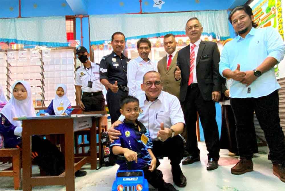 Pengarah JPN Kelantan, Datuk Mohd Zamri Abdul Aziz meraikan Abdul Hakim Saifuddin sempena tinjauan hari pertama pembukaan sekolah sesi akademik 2024/2025 di SK Ismail Petra 1 di Kota Bharu.