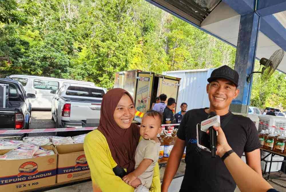 Mohamad Faizal bersama keluarga datang untuk membeli barangan di PJR Madani di Padang Kawad PGA Kinarut, Papar.