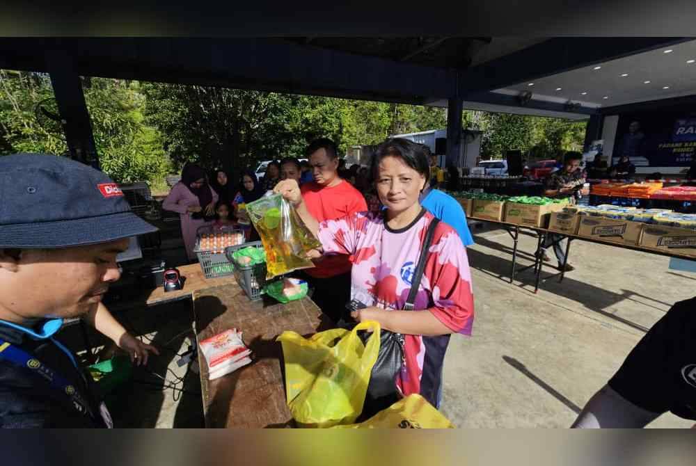 Julia menunjukkan minyak masak peket antara yang menjadi buruan pengunjung PJR Madani di Padang Kawad PGA Kinarut, Papar.