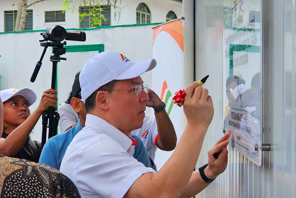 Kor Ming menandatangani plak simbolik merasmikan Pusat Komuniti Sifar Sisa (KOSIS) Rumah Pangsa Jalan Hospital di Ipoh.
