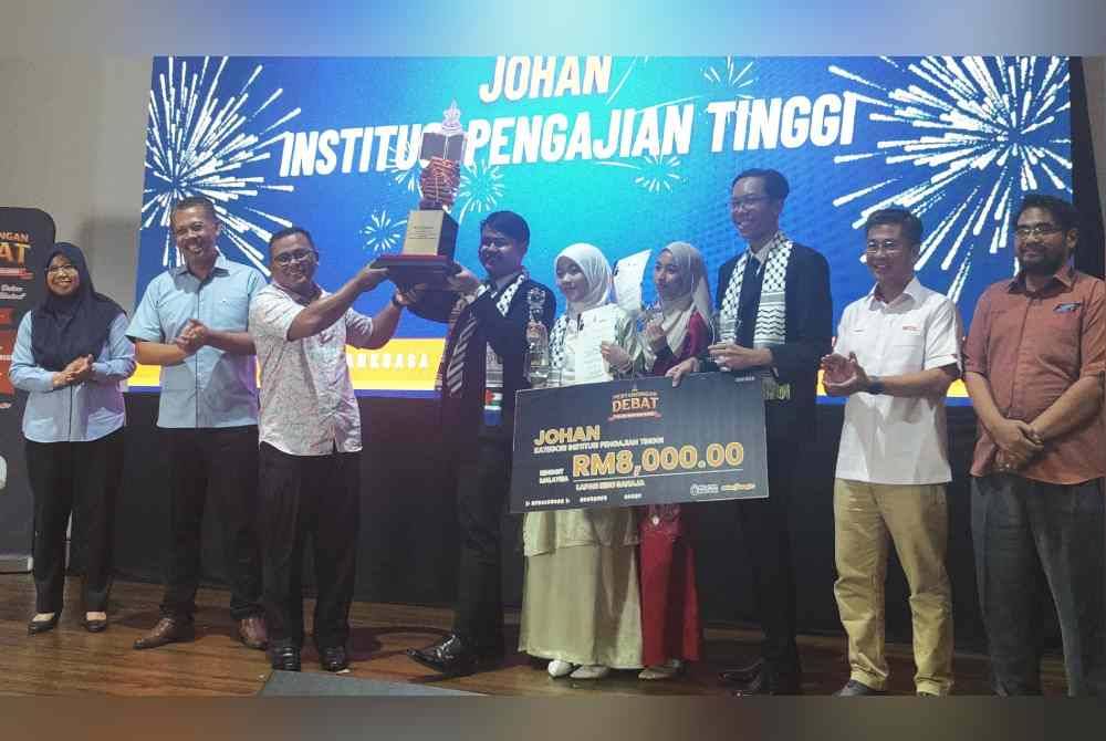 Amirudin (tiga dari kiri) menyampaikan hadiah kemenangan kepada pendebat USIM pada Pusingan Debat Piala Dato' Menteri Besar Selangor di STDC pada Ahad.