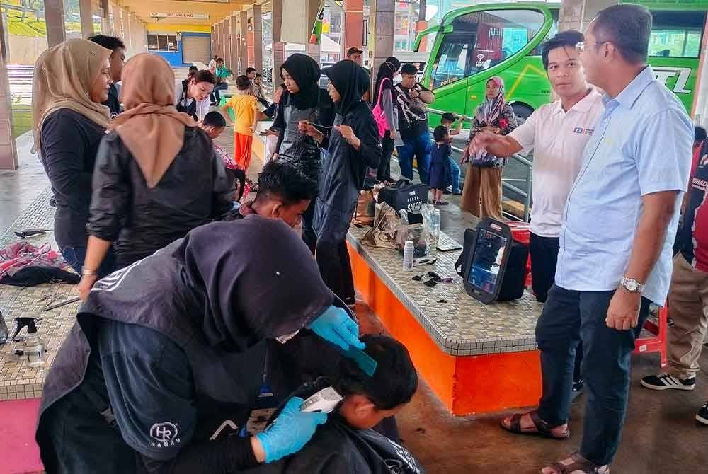 Syahril (Kiri) dan Ridzuan (kanan) ketika menyantuni peserta yang terlibat dalam program tersebut