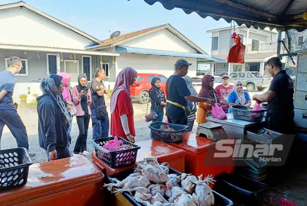 Orang ramai beratur untuk membeli ayam di Pasar Seksyen 30, Shah Alam pada Ahad.