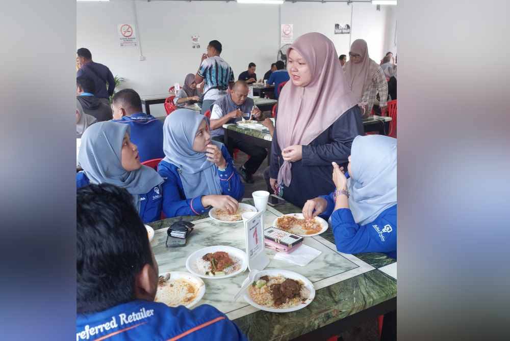 
Siti Aishah (dua dari kanan) beramah mesra dengan pelanggannya.